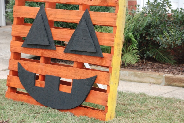 A pallet decorated like a pumpkin for halloween decorations